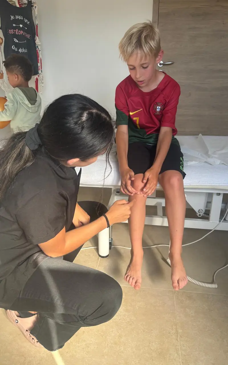 Melissa examine le genou d'un jeune footballeur